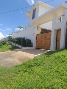 a white house with a fence and a driveway at Jumba paradise in Mtwapa