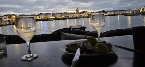 a table with two wine glasses and a plate of food at yacht Twenty Seven in Les Sables-d'Olonne