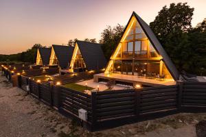 a row of lodges with lights on them at night at Cabane Masaya Aframe in Periş