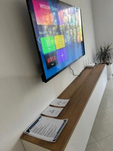 ein Flachbildfernseher, der an einer Wand hängt in der Unterkunft Bloom Haven in Kashari