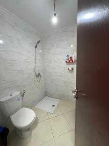 a bathroom with a toilet and a shower at Appartement Nador center Diar aarid in Nador
