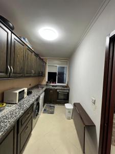 a kitchen with a sink and a microwave at Appartement Nador center Diar aarid in Nador +3 photos