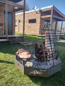 a grill with meat on it in front of a cabin at Cabañas Olavarría in Olavarría