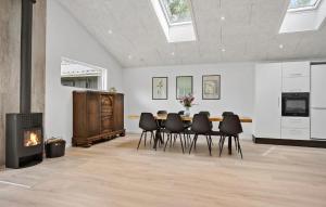 a dining room with a table and chairs and a fireplace at 3 Bedroom Stunning Home In Spøttrup in Spottrup