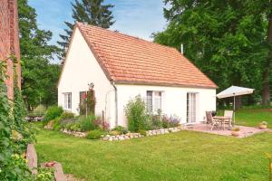 een klein wit huis met een tuin en een tafel bij Backhus Nordkampen in Walsrode