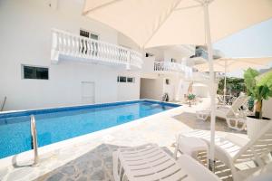 a villa with a swimming pool and white chairs at Villa Champion in Ulcinj