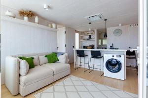 a living room with a couch and a washing machine at Villa Nautilus Buqez Resort in Drage