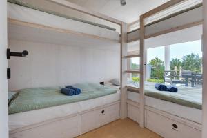 two bunk beds in a room with a window at Villa Nautilus Buqez Resort in Drage