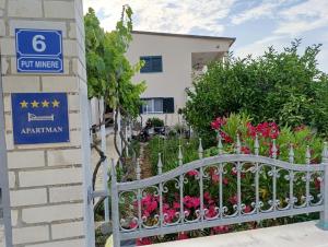 a sign in front of a building with flowers at Vila Ivana Dolores in Vinišće