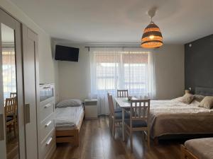 a bedroom with a bed and a table and chairs at Pokoje Gościnne REST in Karwia