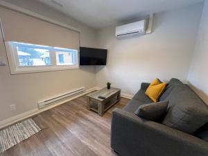 a living room with a couch and a tv at Adrian's Suites 1 Bedroom Junior Suite in Wasaga Beach