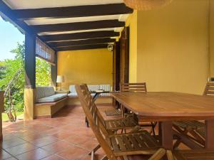 a dining room with a wooden table and chairs at Villa Giò Geremeas fronte mare in Marongiu