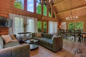 a living room with couches and a dining room at Log Cabin Hot tub near Tremblant in Labelle +68 photos
