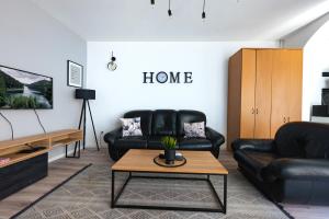 a living room with two black leather chairs and a coffee table at Industrial Home Vršac in Vršac +21 photos