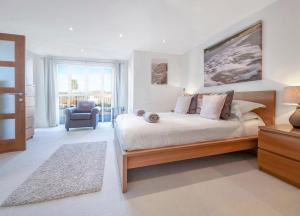 una camera da letto con un letto grande e una sedia di Point View - Award Winning Apartments with Private Hot Tub & Parking a Croyde Altre 37 foto