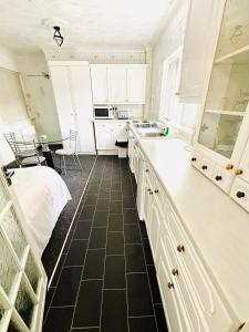 a kitchen with white cabinets and a black tile floor at Springfield Holiday Apartments HALodge Hotel in Skegness +39 photos