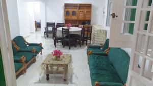 a living room with green couches and a table at قرية ظلال النخيل العريش in El Arish