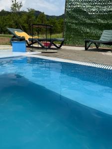 a blue swimming pool with a picnic table and a swing at CABANA ZIMBRU in Băile Borşa