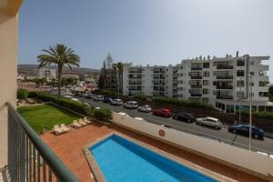 balkon z basenem i ulicą miejską w obiekcie Los Ficus, Maspalomas w mieście Playa del Ingles