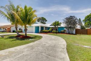 a house with palm trees and a driveway at Private Pool and Yard Family Home in Port St Lucie in Walton