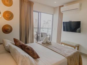 a bedroom with a large bed with a large window at Bocagrande Infinitum Vista mar Gym Coworking in Cartagena de Indias