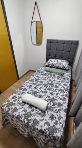 - un lit avec une couverture noire et blanche et un miroir dans l'établissement Seu refúgio no coração da cidade, à Paulo Afonso