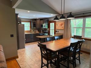 a large kitchen with a wooden table and chairs at 3BR Home - Near The Landing - Free Tickets Included - Cottonwood Cottage in Branson