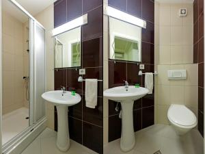 a bathroom with two sinks and a toilet and a shower at Villa Miranda NG in Ohrid