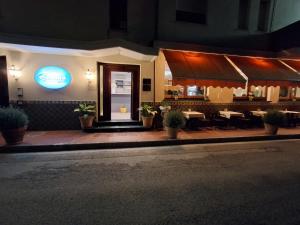 a restaurant with tables and a sign on the building at Albergo Gemma in Roseto degli Abruzzi