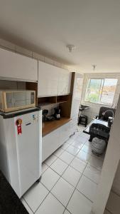 a kitchen with a white refrigerator and a table at Apartamento no Athenas Park V 2o Andar in São Luís