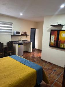 una camera d'albergo con letto giallo e cucina di Estancia Colobri a Guadalajara Altre 33 foto