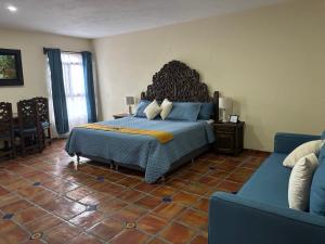 a bedroom with a large bed and a couch at Estancia Colobri in Guadalajara