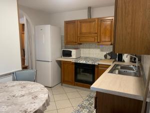 a kitchen with wooden cabinets and a white refrigerator at Casetta STELLA MARINA PUNTA SABBIONI in Cavallino-Treporti