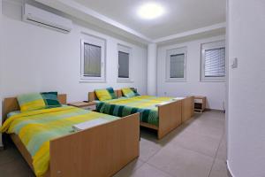 two beds in a white room with windows at Villa Miranda NG in Ohrid