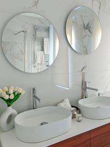 a white bathroom with two mirrors and a sink at Royal Fraga do Douro in Vila Real