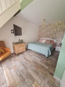 a bedroom with a bed and a television in it at Dépendance entre CAEN et la mer in Lasson