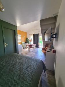 a bedroom with a bed and a living room at Dépendance entre CAEN et la mer in Lasson