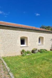 a brick building with two windows and a grass yard at Dépendance entre CAEN et la mer in Lasson +12 photos