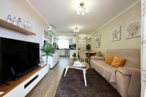 een woonkamer met een grote televisie en een bank bij Madalena Sunset by Mill Escapes in Madalena do Mar