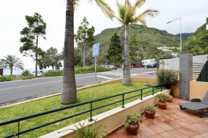 een balkon met palmbomen en een straat bij Madalena Sunset by Mill Escapes in Madalena do Mar