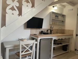 a kitchen with a counter and a table under a staircase at Rodakas Rooms-Dafni in LivadhokhÃ³rion
