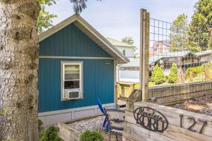 a blue house with a tree and a fence at Mountain Koru Near Trails & Town cabin in Thomas +17 photos