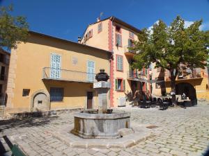 a fountain in the middle of a street next to a building at La Maison de la Tour in La Tour +28 photos