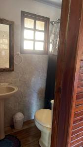 um banheiro com vaso sanitário, pia e janela em Chalé Mississippi - Camping Carrion - ITU em Itu