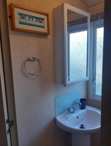 a bathroom with a sink and a window at Happy Days Chapel st Leonard's The Ocean Pearle in Chapel Saint Leonards