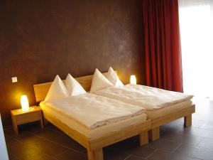 two twin beds in a room with two candles at Hotel Restaurant Jura in Kerzers