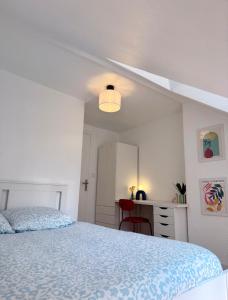 ein weißes Schlafzimmer mit einem Bett und einem Schreibtisch in der Unterkunft Art district Triplex next to Royal Castle in Blois