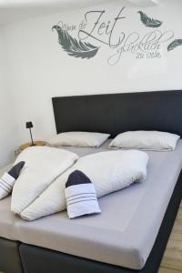 two beds with white pillows and a sign on the wall at Ferienwohnung NiSi in Münsingen