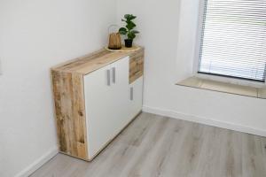a small white refrigerator in a room with a window at Ferienwohnung NiSi in Münsingen