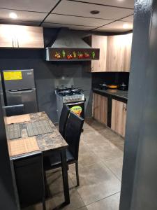 cocina con fogones y mesa con sillas en Alquileres El Ángel, en San Salvador